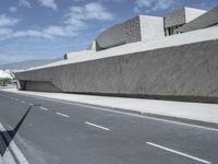 empty road near building under blue sky in daylight day with clouds overhead in daylight day