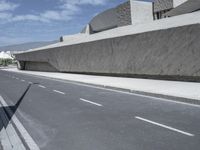 empty road near building under blue sky in daylight day with clouds overhead in daylight day