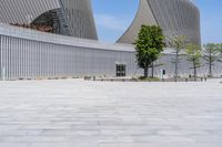 the large building has many windows and lights on it's sides and is standing in a courtyard