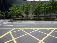 a man on the corner of an intersection in front of a building, with a pedestrian crossing the road