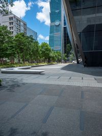 there are some buildings near each other and the ground has paving tiles on it and trees around