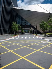 an asphalt parking lot with yellow lines painted all over it in front of the building