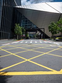 an asphalt parking lot with yellow lines painted all over it in front of the building