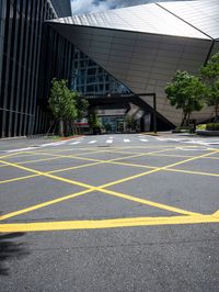 an asphalt parking lot with yellow lines painted all over it in front of the building