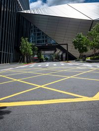 an asphalt parking lot with yellow lines painted all over it in front of the building