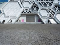 a large white building has some hexagonal lattices in it as the center of the building