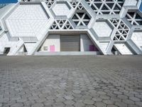 a large white building has some hexagonal lattices in it as the center of the building