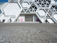 a large white building has some hexagonal lattices in it as the center of the building