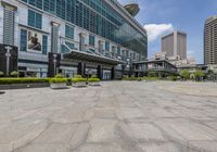 two buildings with a plaza in the foreground, and benches sitting on the ground next to them