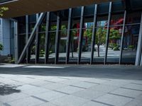 the person is sitting on a bench outside in a city building and riding a skateboard