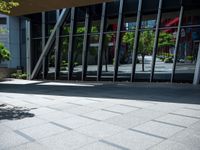 the person is sitting on a bench outside in a city building and riding a skateboard