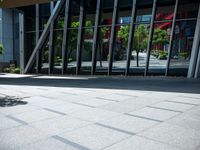 the person is sitting on a bench outside in a city building and riding a skateboard