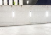 the large concrete wall has been illuminated by recessed lights at night on either side of it