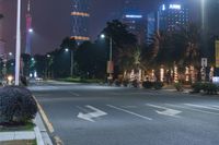 a city street with buildings and neon lights at night time in hong china as seen from an empty city highway