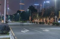 a city street with buildings and neon lights at night time in hong china as seen from an empty city highway