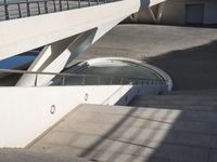 a concrete walkway with many circular objects on the side and sky in the background behind