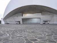 a building is constructed into an archway shape and features a stone floor and a circular walkway