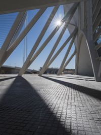 the shadow of the bridge is cast across the cement pavement that has been set out in the shape of a pyramid