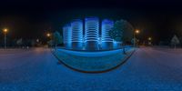 an image of a very futuristic building at night time in the middle of town street