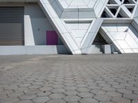 the building with a small blue dog in front is white and is designed like blocks