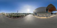 an 360 - lens image of a futuristic building on the street in front of a city street