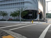 an intersection has traffic lights and building next to it for a pedestrian or cyclist crossing