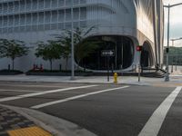 an intersection has traffic lights and building next to it for a pedestrian or cyclist crossing