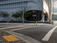 an intersection has traffic lights and building next to it for a pedestrian or cyclist crossing