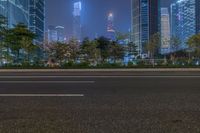 a city street with buildings and neon lights at night time in hong china as seen from an empty city highway