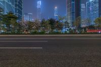 a city street with buildings and neon lights at night time in hong china as seen from an empty city highway