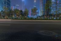 a city street with buildings and neon lights at night time in hong china as seen from an empty city highway