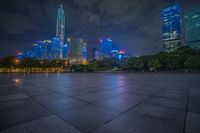 city skyline in the distance with square paving with lights on the ground in the foreground