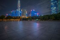 city skyline in the distance with square paving with lights on the ground in the foreground