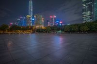 city skyline in the distance with square paving with lights on the ground in the foreground