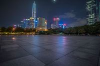 city skyline in the distance with square paving with lights on the ground in the foreground