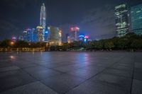 city skyline in the distance with square paving with lights on the ground in the foreground