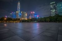 city skyline in the distance with square paving with lights on the ground in the foreground