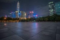 city skyline in the distance with square paving with lights on the ground in the foreground