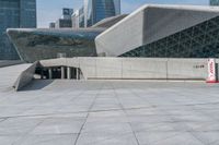 a boy riding his skateboard in front of the building that has a silver exterior