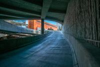 an empty road going between the buildings and a ramp leading to the building is shown