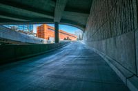 an empty road going between the buildings and a ramp leading to the building is shown