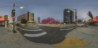 a fish eye photo of a city street with many signs and buildings on it's sides