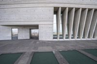 the entrance to an art museum is shown from below view of a concrete structure and green cement walkway