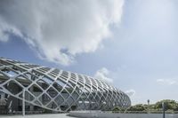an open roof that shows off a building in the background with buildings and clouds in the sky