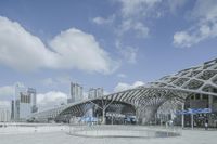 an open roof that shows off a building in the background with buildings and clouds in the sky