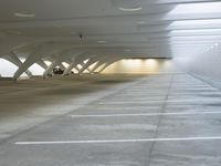 a picture of an empty and parking garage with an empty floor inside of it a car parked in the garage