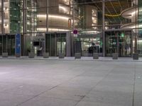 a very big square with some stairs and windows at night time with a fire hydrant sitting in front of it