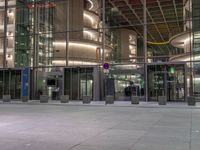 a very big square with some stairs and windows at night time with a fire hydrant sitting in front of it