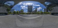 a large mirror is reflecting buildings and sky in this picture and it appears to be like something from a distance