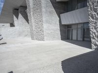 this is an outdoor courtyard with stone steps and a curved concrete wall, that stretches to the outside